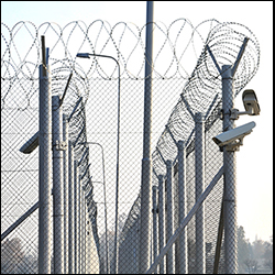 Double barrier secured perimeter fencing with barbed wire and cameras